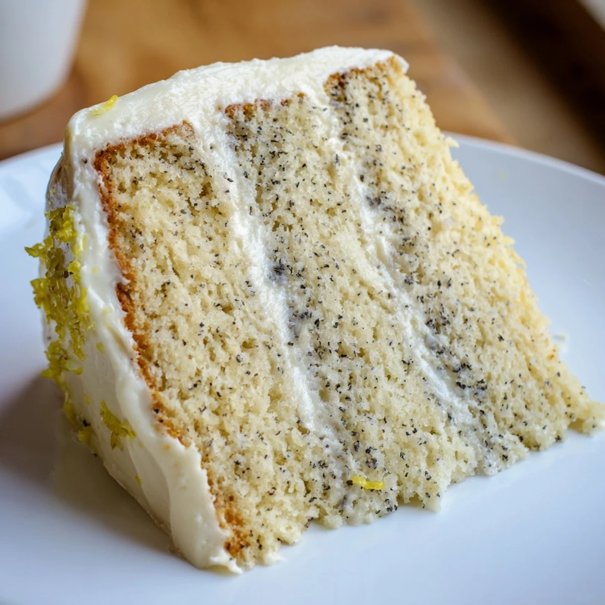 Three-tier London Fog cake decorated with edible flowers and fresh lemon zest sprinkles