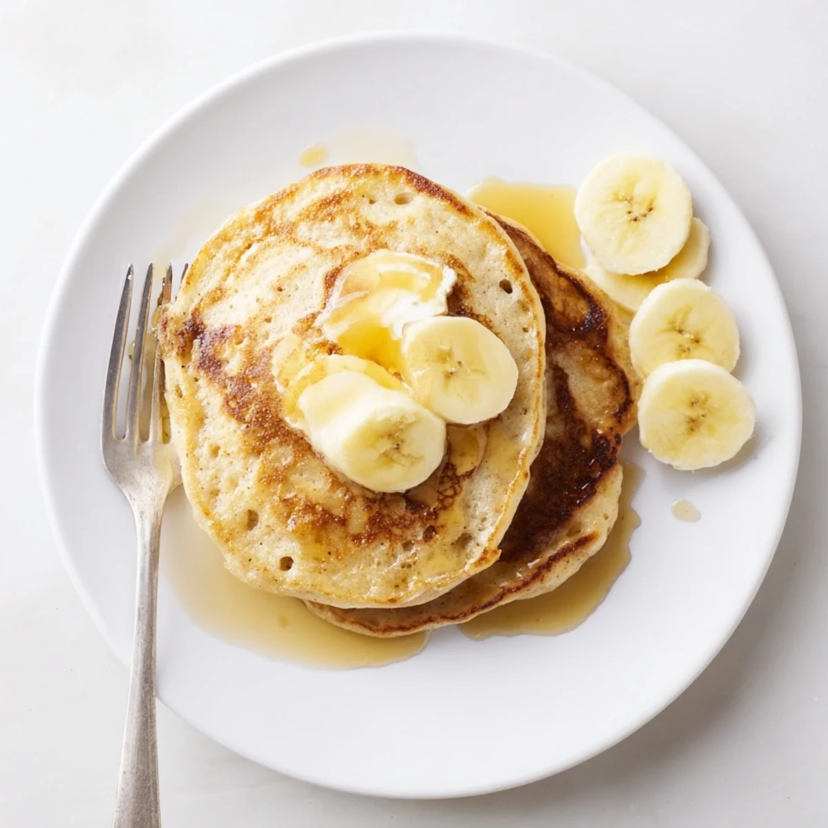 Fluffy Greek yogurt banana pancakes topped with blueberries and honey on a rustic wooden breakfast table