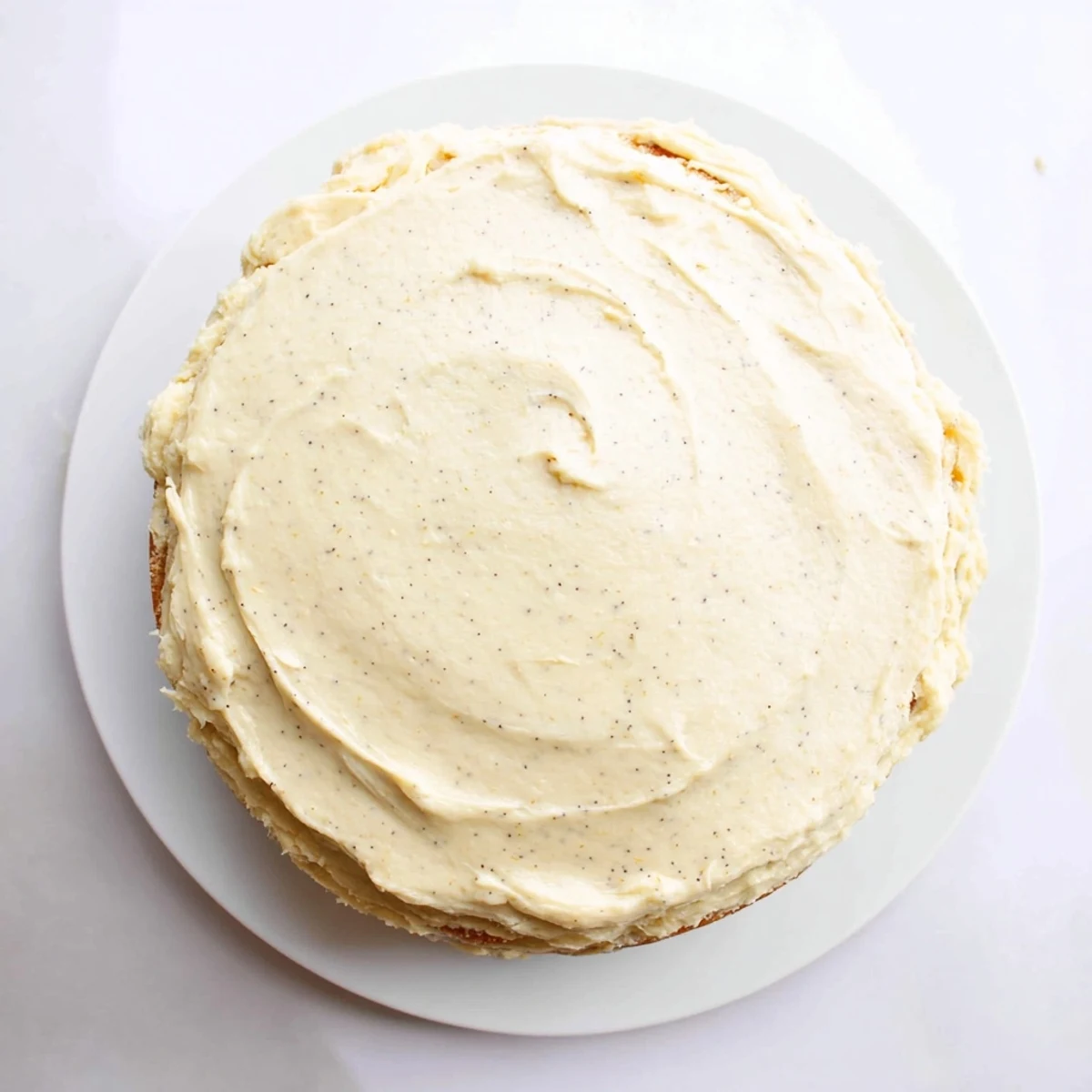 Layered vanilla bean birthday cake with smooth buttercream frosting and colorful sprinkles on top