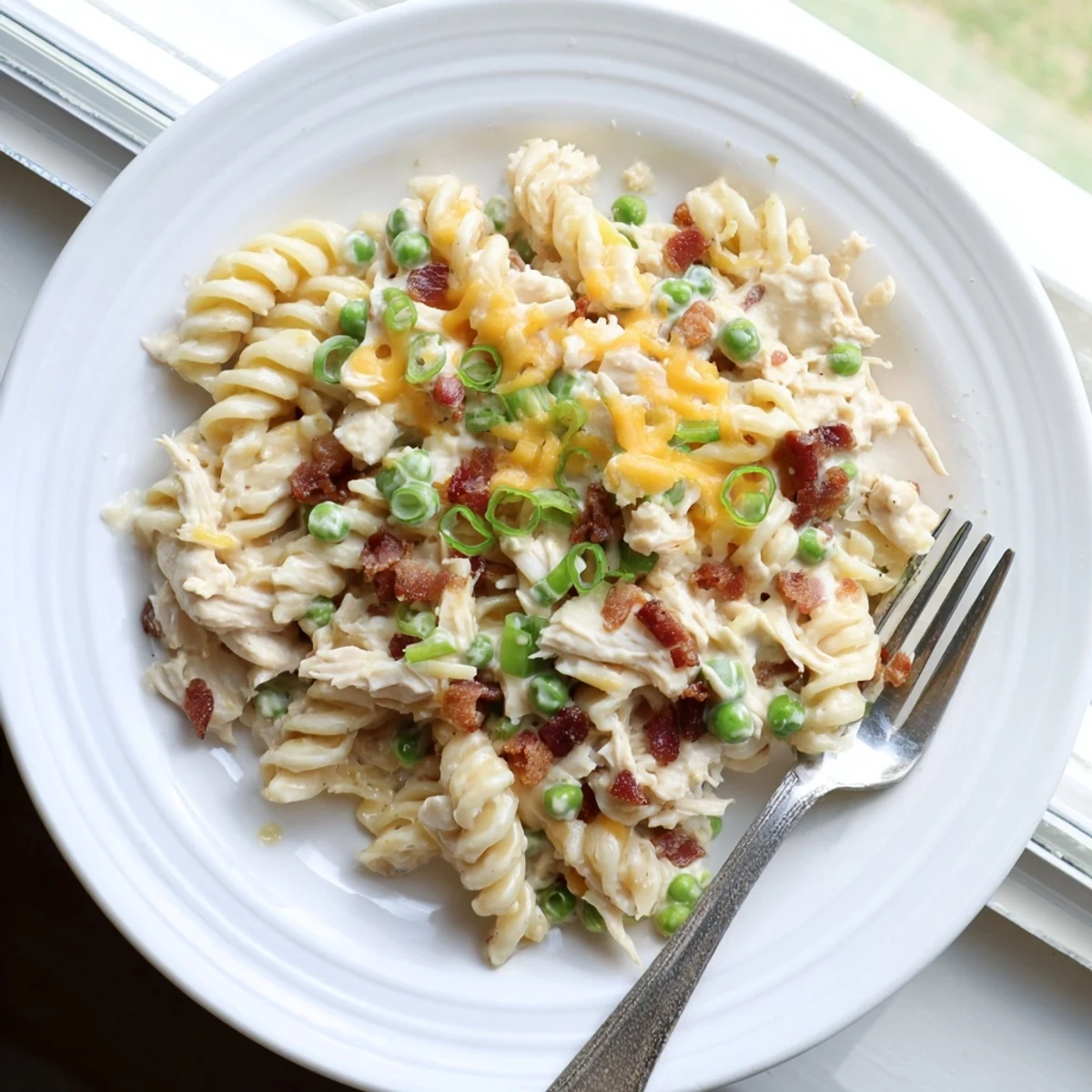 Creamy slow cooker Crack Chicken Casserole with tender pasta, ranch seasoning, and shredded cheese
