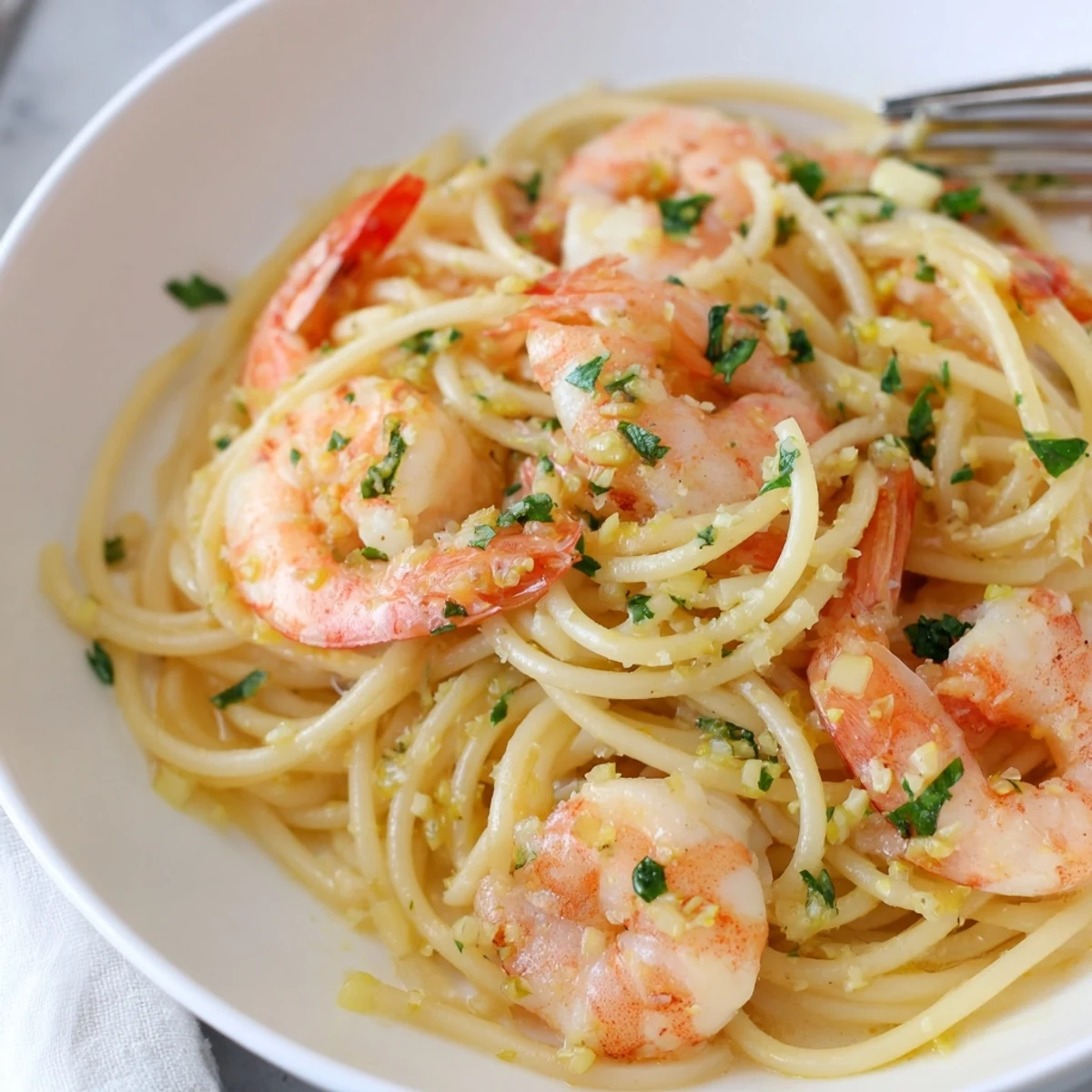 Golden shrimp scampi pasta glistening with garlic butter sauce and fresh parsley garnish