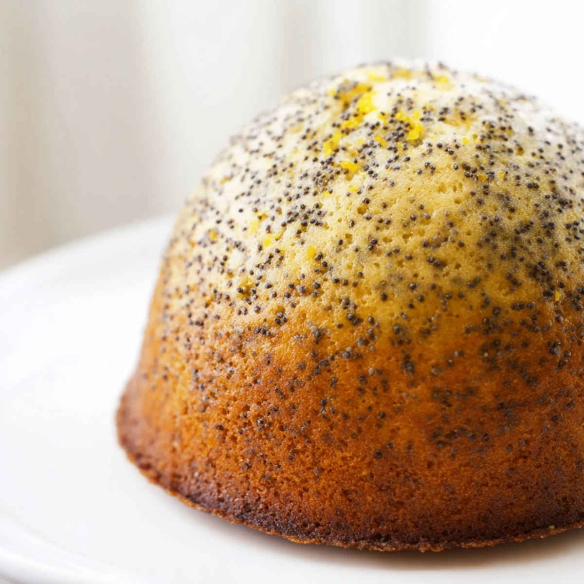 Golden lemon poppy seed muffins with domed tops fresh from the oven on a wire cooling rack