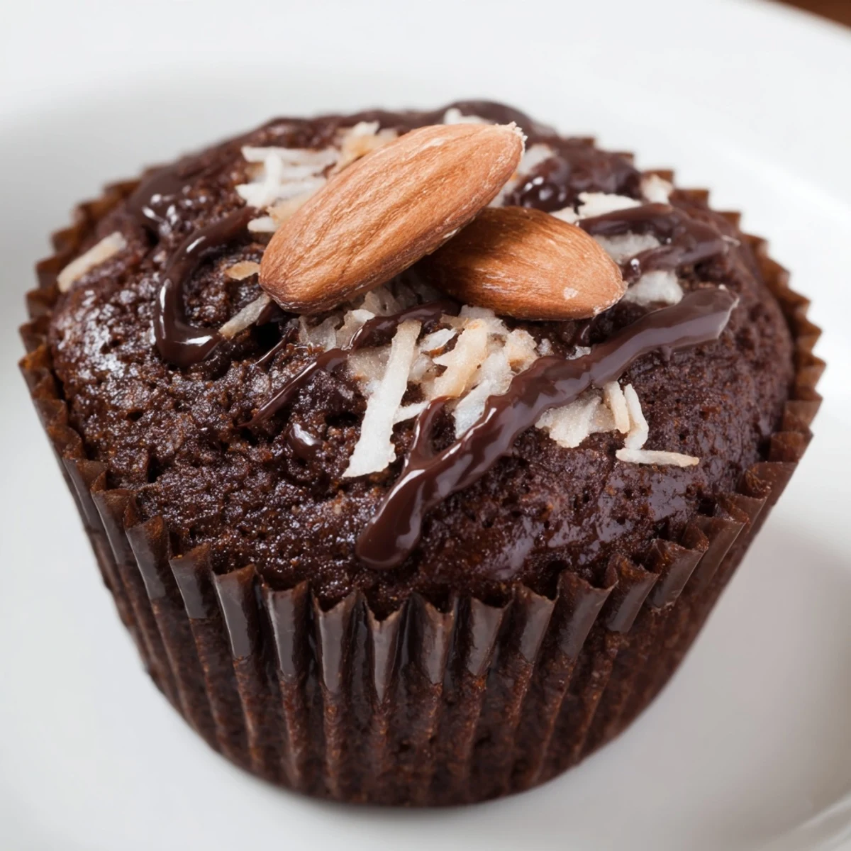 Fudgy flourless almond joy cupcakes garnished with shredded coconut sweet condensed milk and almonds
