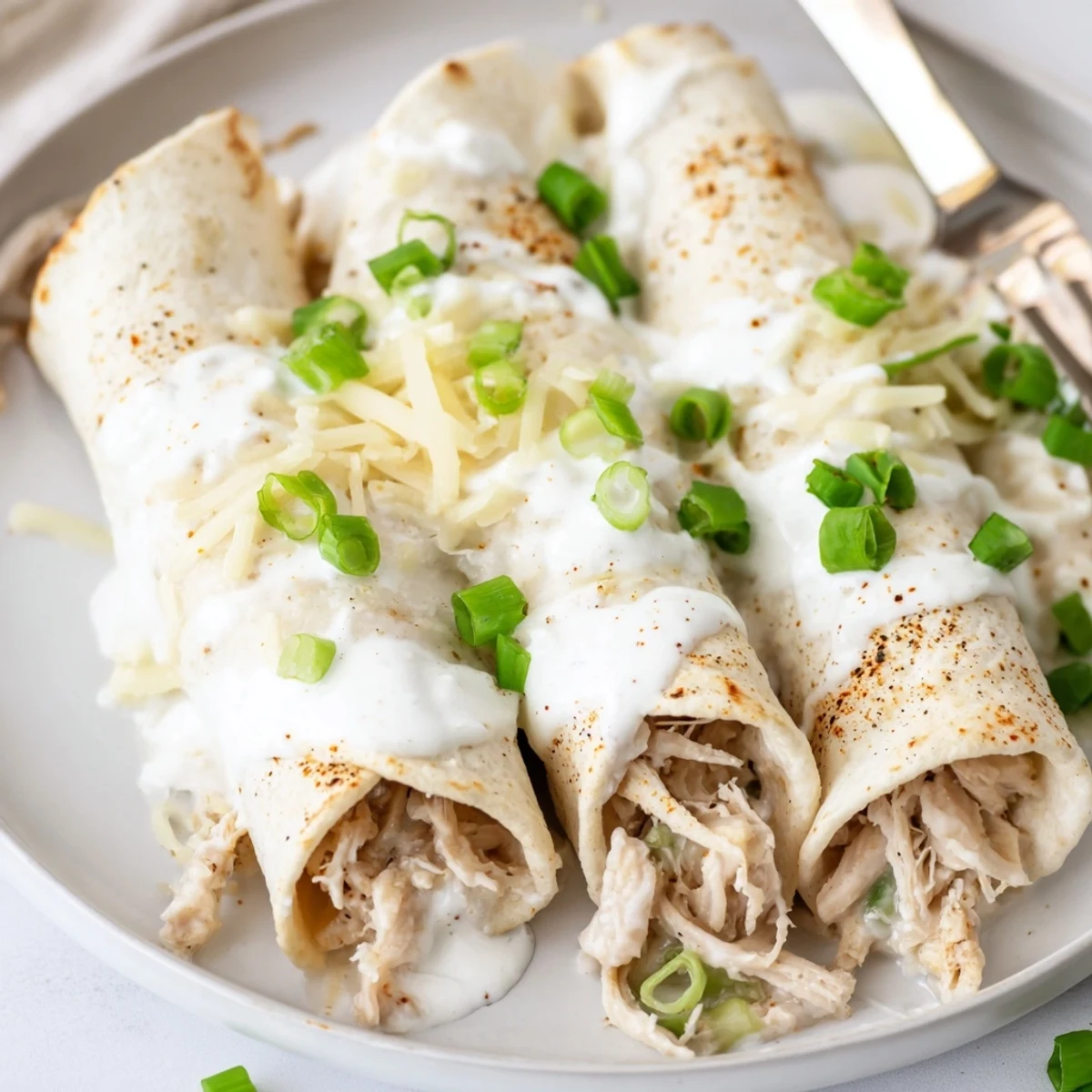 Fresh from oven, Creamy White Chicken Enchiladas topped with sour cream.