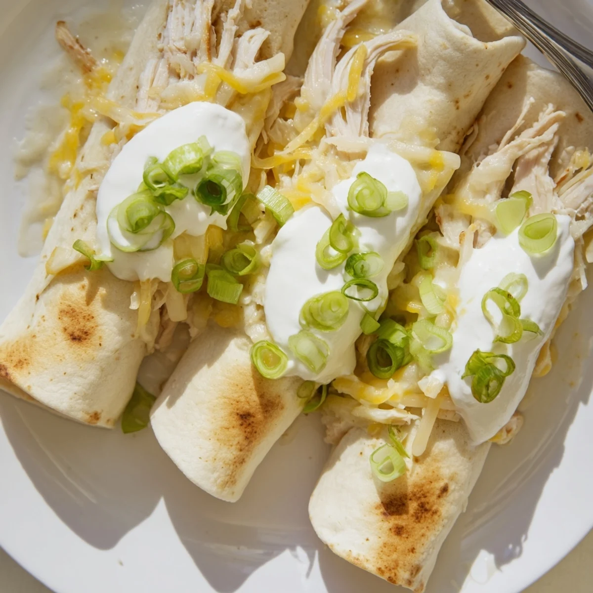 Stacked Creamy White Chicken Enchiladas in a baking dish, velvety sauce sheen.