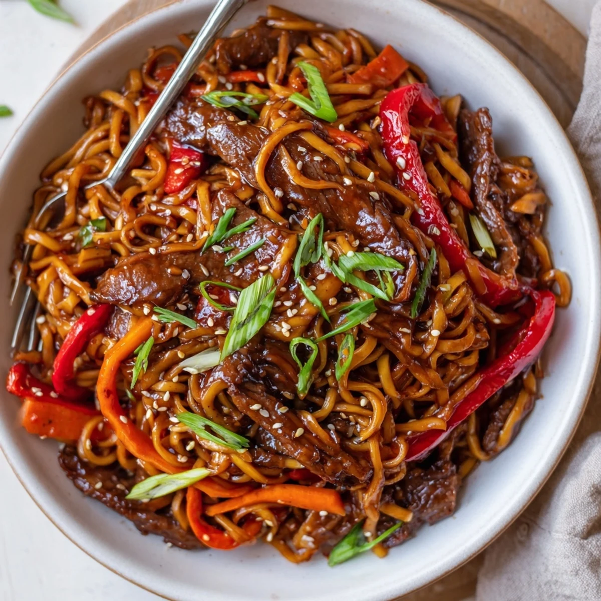 Sticky Beef Noodles glistening with glossy sauce, tender beef and sesame garnish