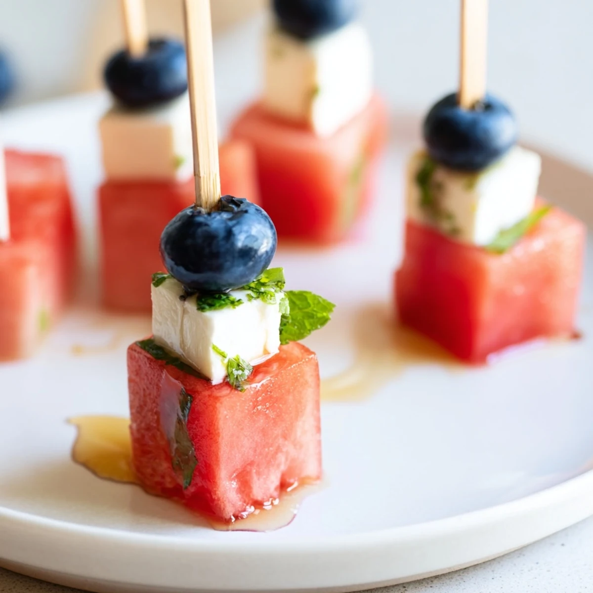 Patriotic Watermelon Feta Skewers with blueberries and mint, chilled summer appetizer.
