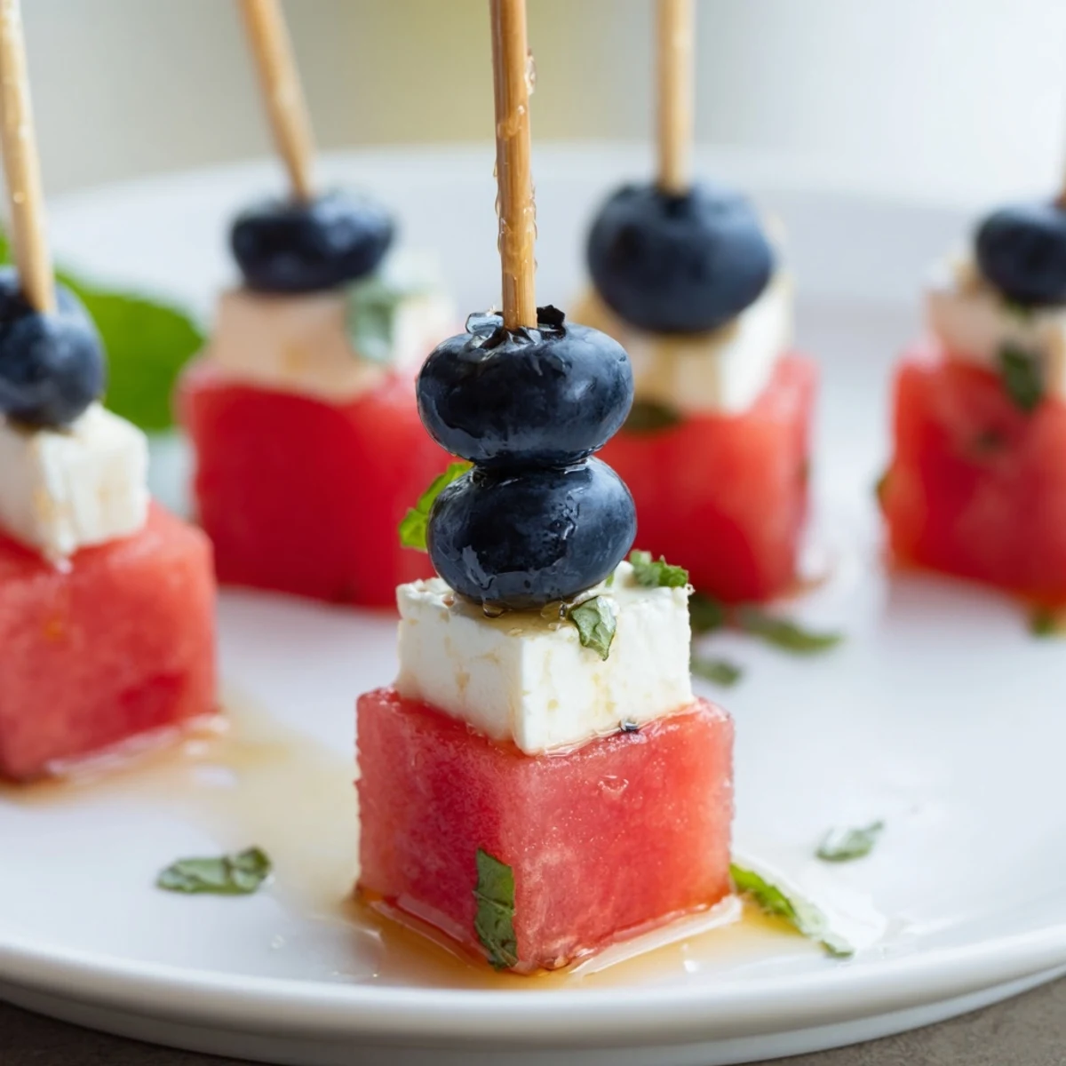 Bright Patriotic Watermelon Feta Skewers drizzled with honey, perfect picnic finger food.