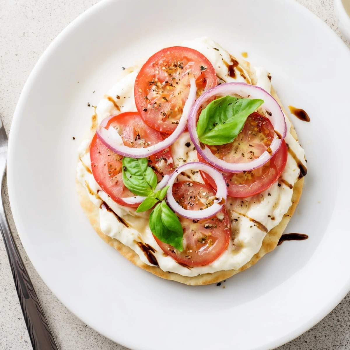 Oven-golden Caprese Pita Pizza With Whipped Garlic Feta drizzled with balsamic