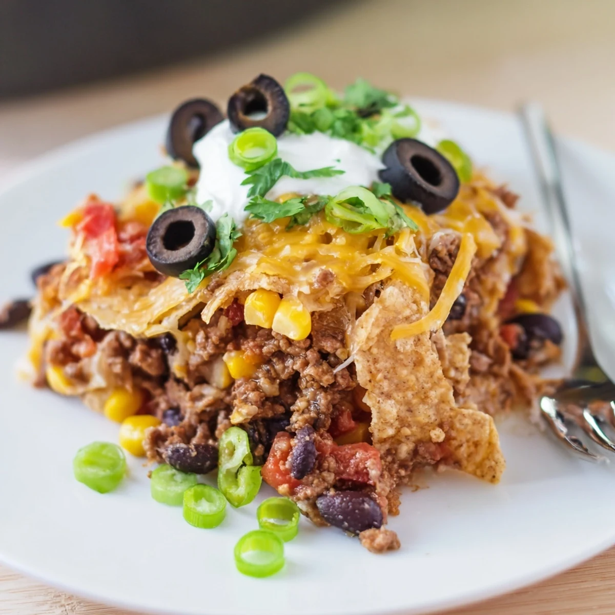Baked Cheesy Nacho Casserole steaming in dish, crunchy chips, zesty jalapeños