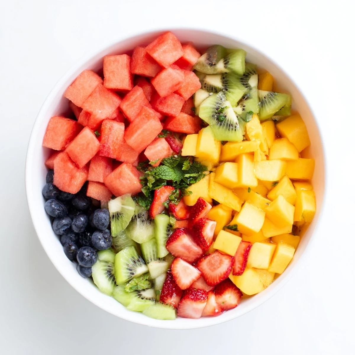 Vibrant mix of watermelon mango and strawberries coated in sweet citrus honey glaze