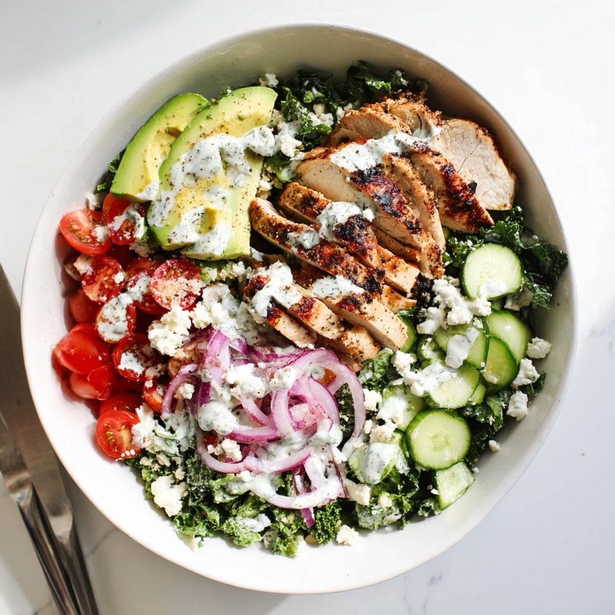 Wholesome marinated kale and chicken bowl featuring tender sliced protein with crisp veggies and zesty homemade dressing