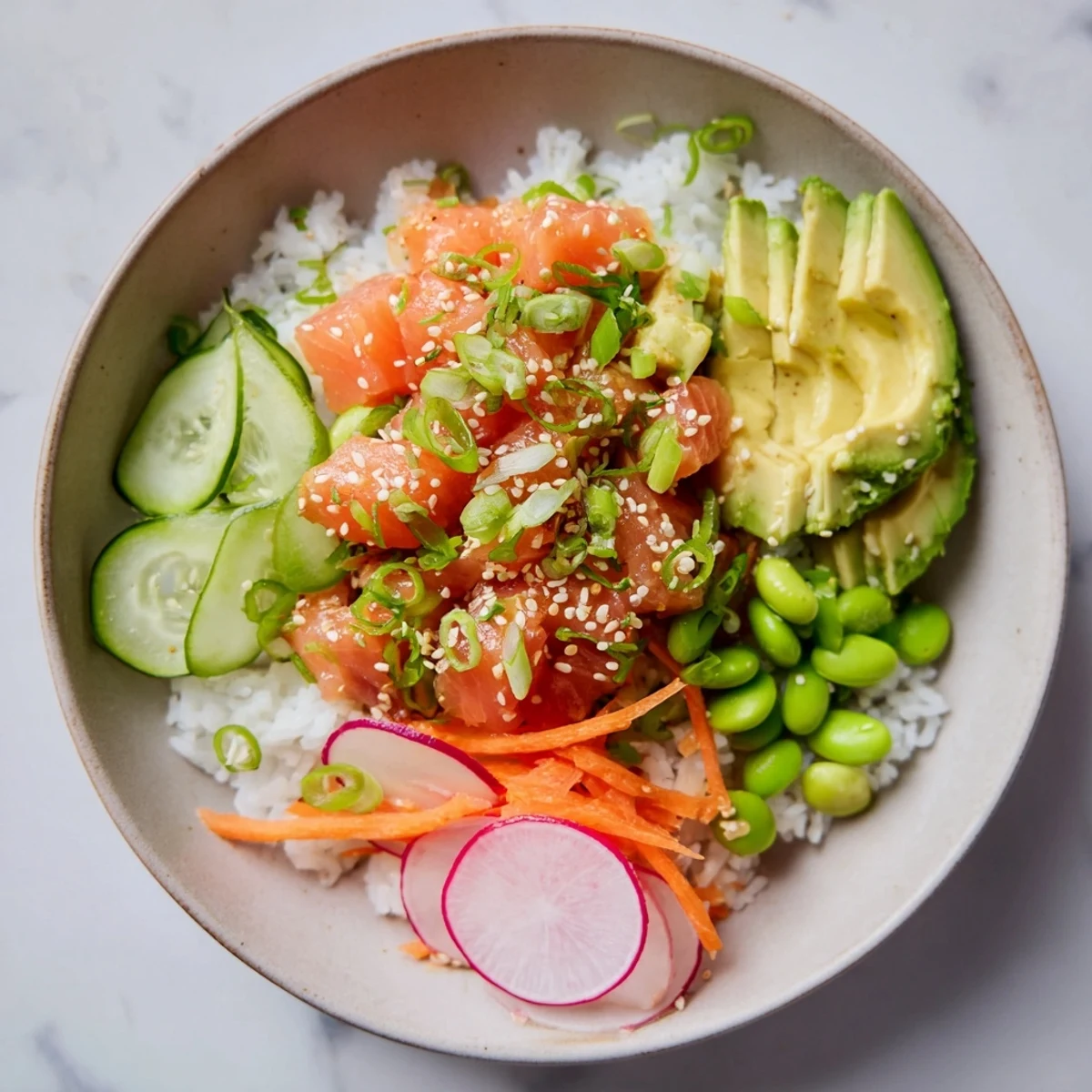 Fresh diced salmon and creamy avocado poke bowl served with tangy savory sauce
