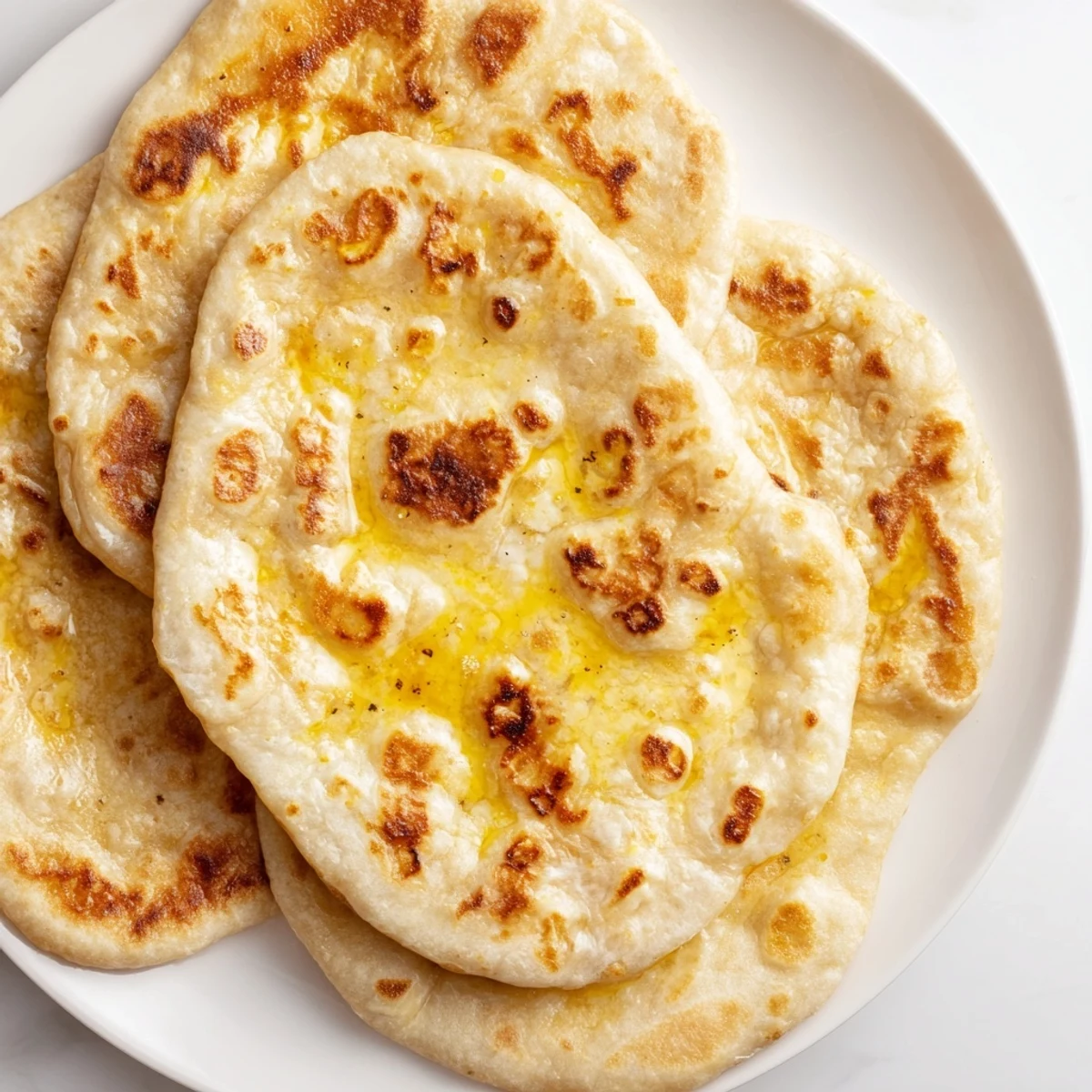 Fluffy Turkish Bazlama flatbread brushed with olive oil and ready for dipping
