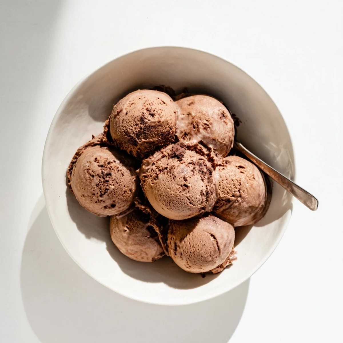 Creamy chocolate sourdough ice cream scooped into a chilled glass bowl with dark chocolate shavings on top