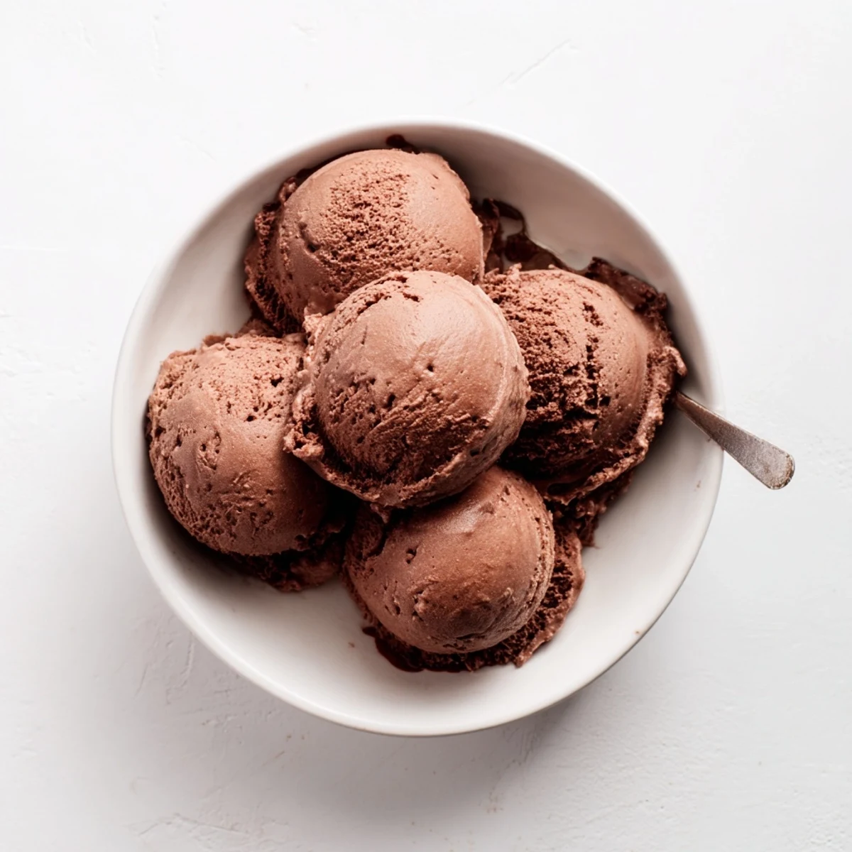 Homemade chocolate sourdough ice cream displaying velvety texture in a vintage white ceramic serving bowl