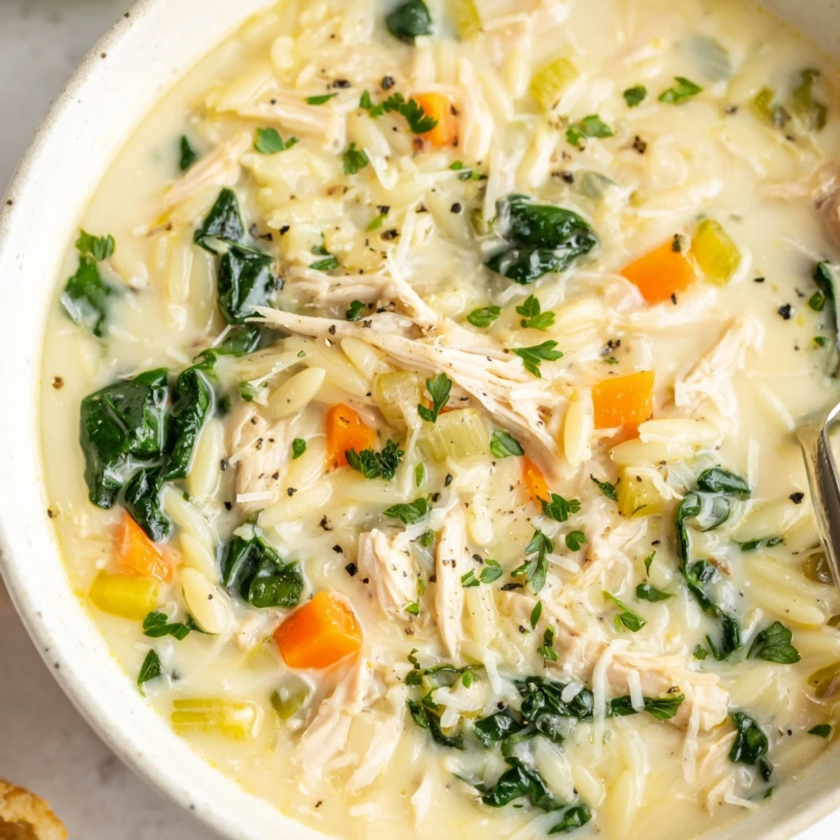 Creamy Chicken Florentine Soup With Orzo steaming in bowl, tender spinach and chicken