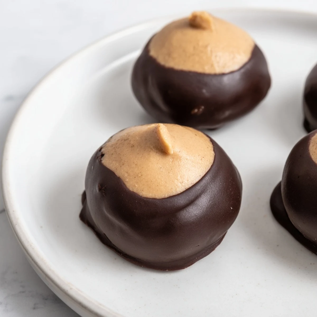Creamy peanut butter buckeye cookies partially dipped in rich melted semisweet chocolate