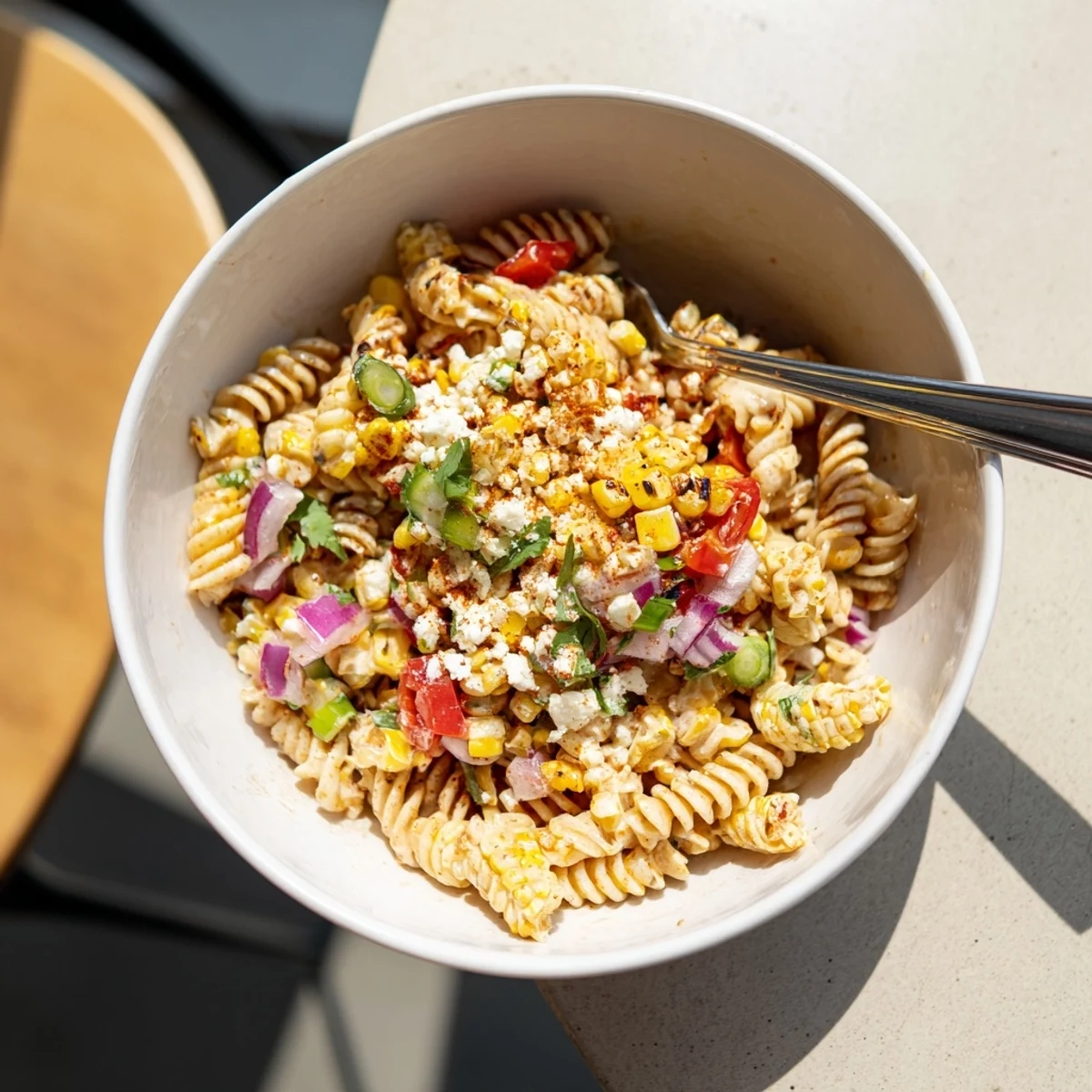 Vibrant Elote Street Corn Pasta Salad served in a rustic bowl with charred corn kernels and diced avocado