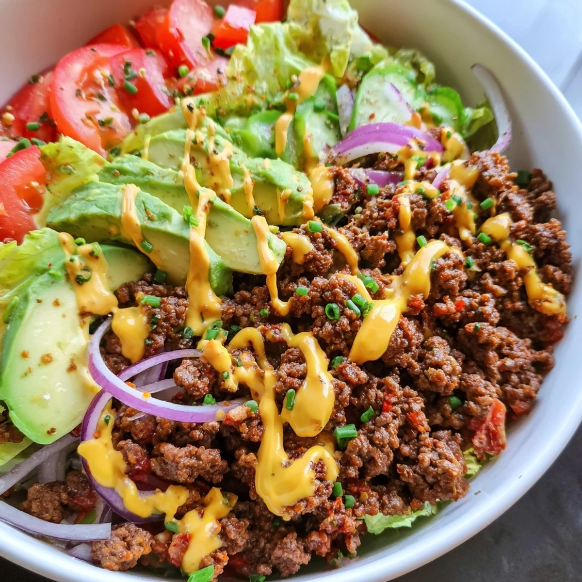 Juicy ground beef burger bowls topped with ripe avocado, crisp lettuce, and tangy pickles