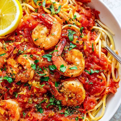 Spicy shrimp fra diavolo served over steaming spaghetti with a sprinkle of basil