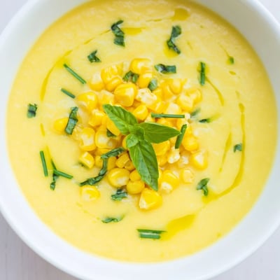 Golden summer sweet corn gazpacho topped with whole kernels and a drizzle of olive oil